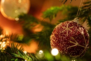 Rote Weihnachtskugel an Tannenzweigen